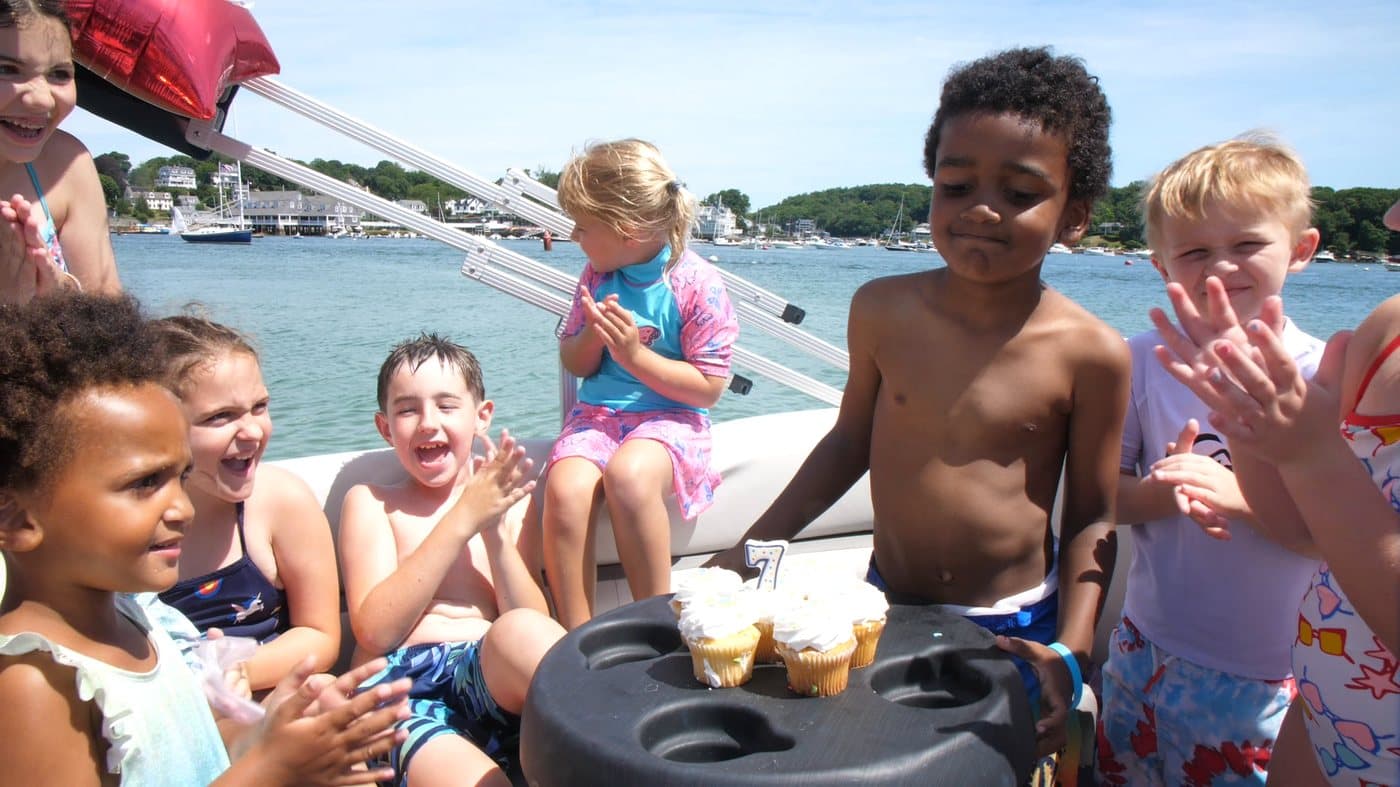 A member relaxed at the helm of a Carefree boat on calm water
